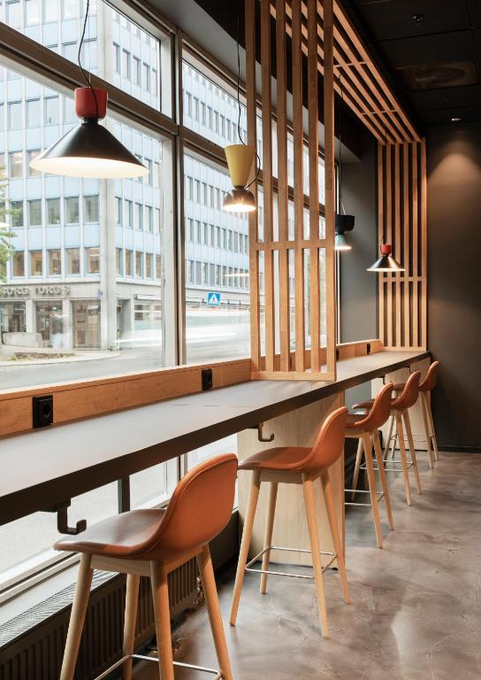 a row of tables and chairs in a room with windows at Comfort Hotel Xpress Youngstorget in Oslo