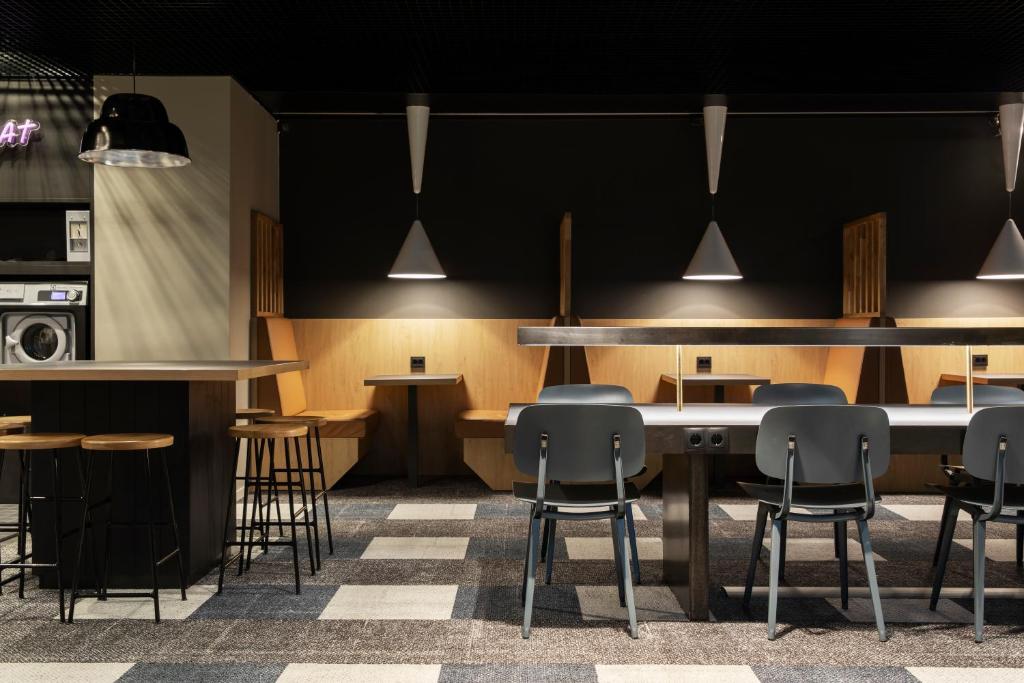 a bar with chairs and a table in a room at Comfort Hotel Xpress Youngstorget in Oslo