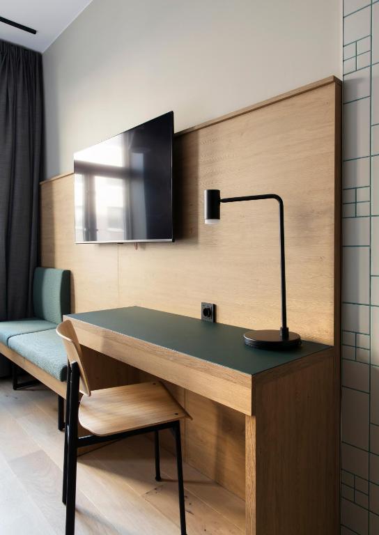 a desk with a lamp and a chair in a room at Comfort Hotel Xpress Youngstorget in Oslo