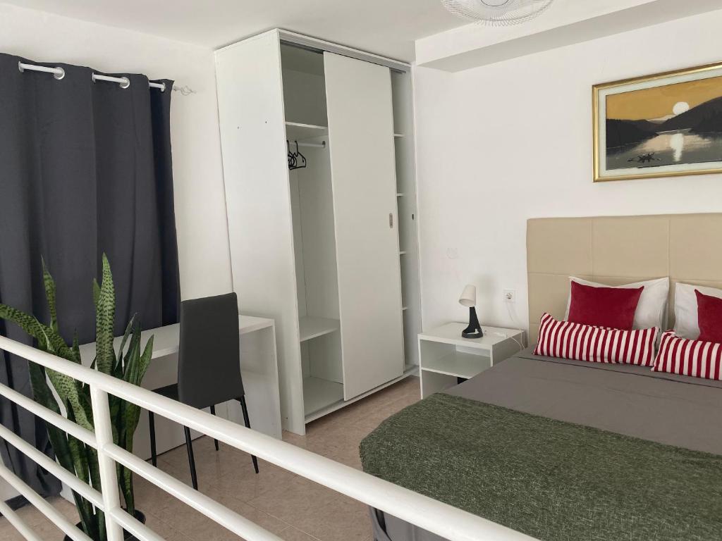 a bedroom with a bed and a desk and a chair at Amilcar Cabral Loft in Praia