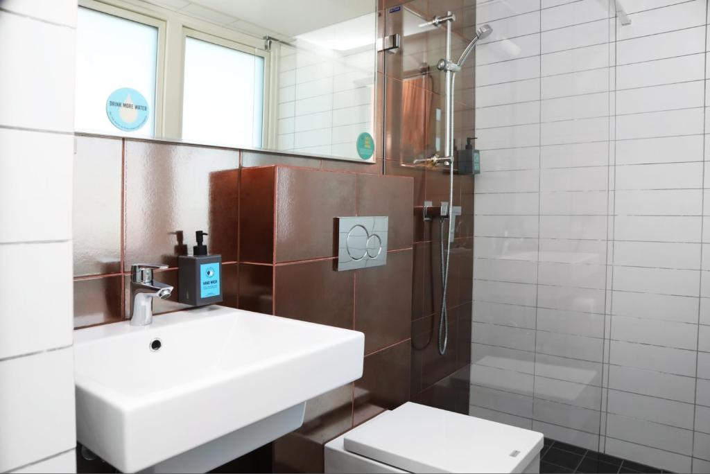 a bathroom with a sink and a toilet and a shower at Comfort Hotel Xpress Youngstorget in Oslo