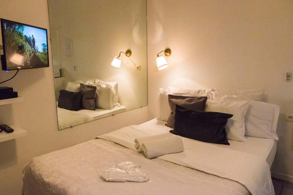 1 dormitorio con 1 cama blanca grande y espejo en Paris Lady Mimi, en París
