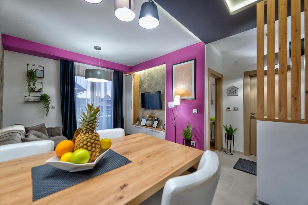 a dining room with a wooden table with a bowl of fruit at Apartments Mons in Vila Katalina in Zlatibor