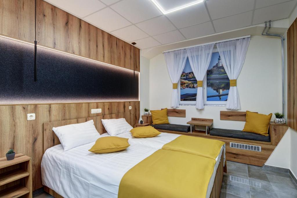 Riverside Inn - dunaparti szuterén في جيور: غرفة نوم بسرير كبير مع مخدات صفراء