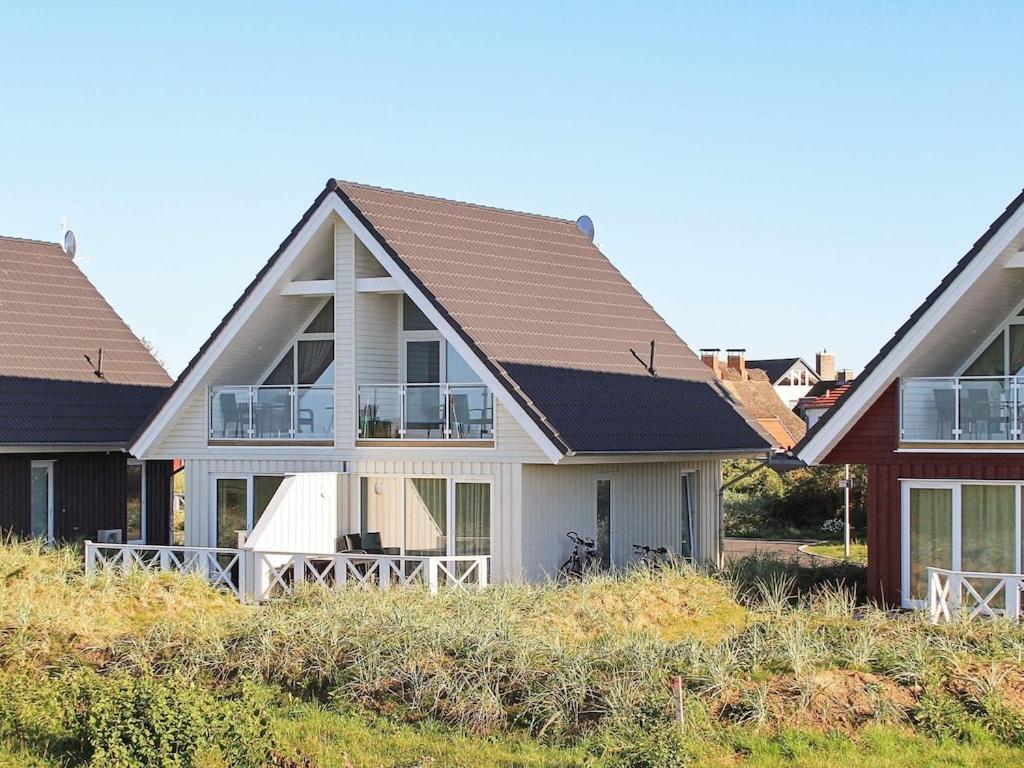 ein weißes Haus mit braunem Dach in der Unterkunft Two-Bedroom Holiday home in Wendtorf 12 in Wendtorf