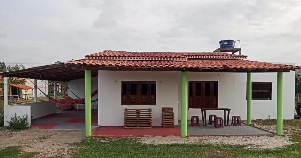 uma pequena casa branca com um telhado vermelho em Casa Gael (Gisele & Lucimar) em Atins