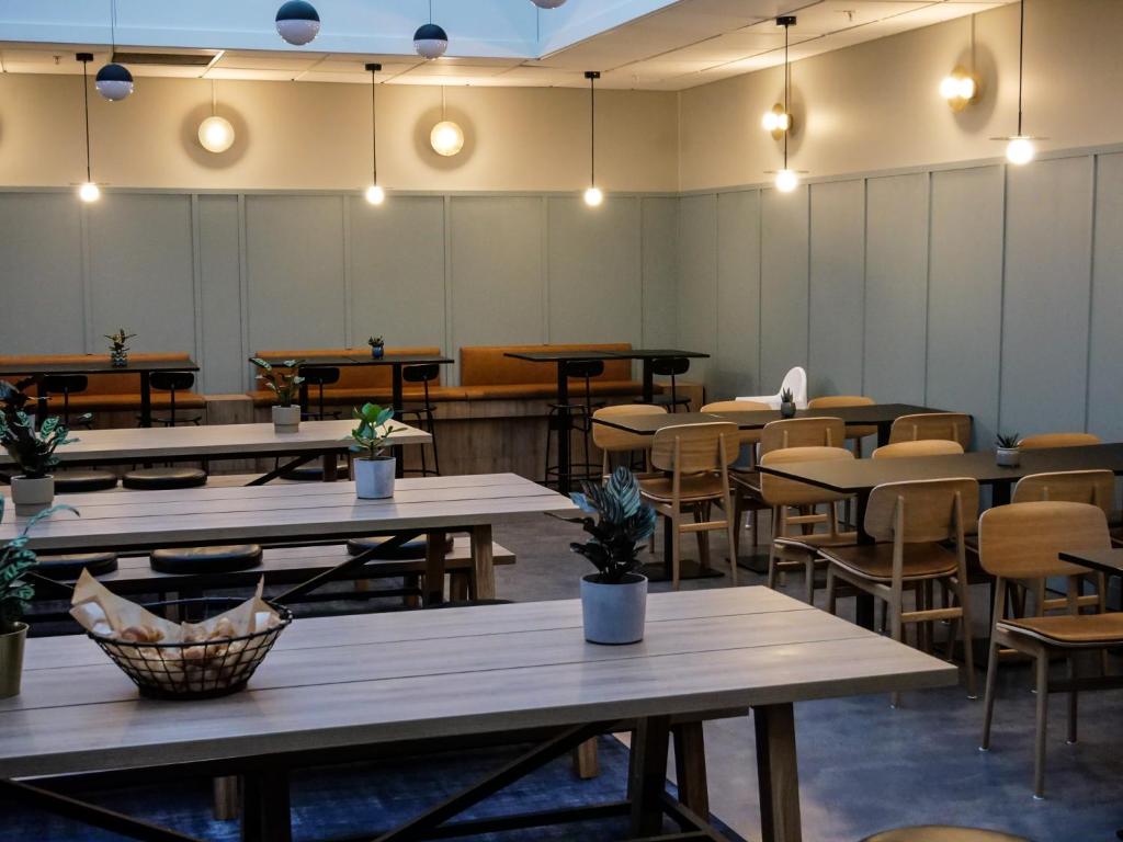 an empty restaurant with tables and chairs and lights at Comfort Hotel Børsparken in Oslo