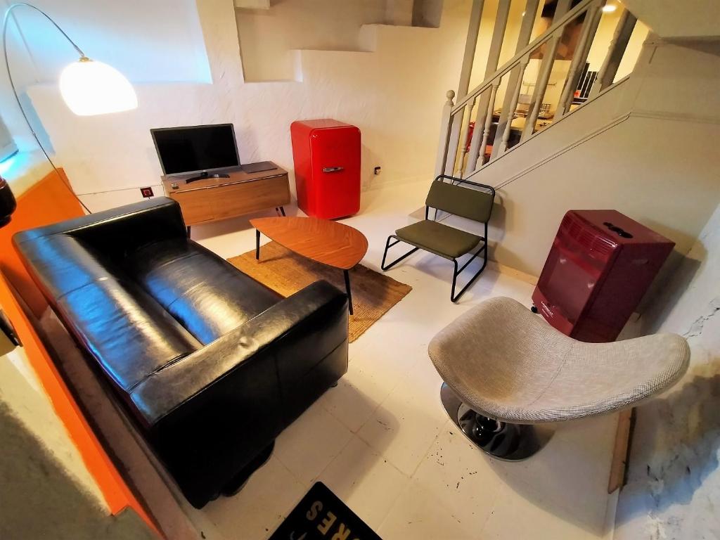 sala de estar con sofá de cuero y silla en Loft Borines, en Borines