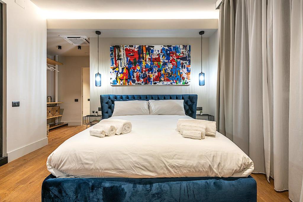 um quarto com uma cama grande com duas almofadas em VicomilleSuites Cagliari em Cagliari