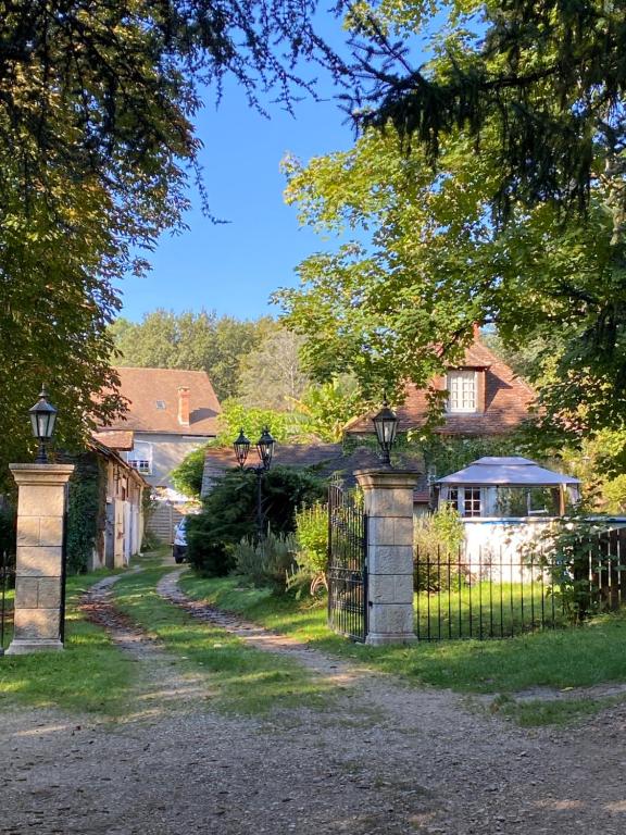 una puerta en un patio con una casa en Domaine le Manoir, gîtes de charme et de caractère avec piscines privatisées et spa nordique, en Fossemagne