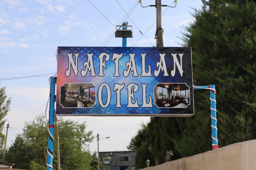 a sign for a nederlandian motel on a street at Beylagan Naftalan Hotel in Beylǝqan