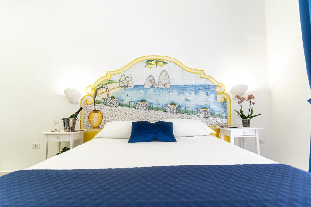 Un dormitorio con una cama azul y blanca con almohadas azules en Biù b&b, en Castellammare di Stabia