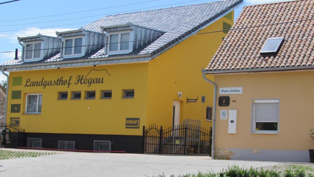 un edificio amarillo con un cartel. en Alt Baden Apartement, en Dunaszekcső