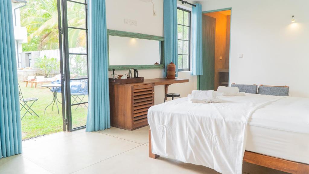 a bedroom with a bed and a desk and window at The Southern Heritage in Galle