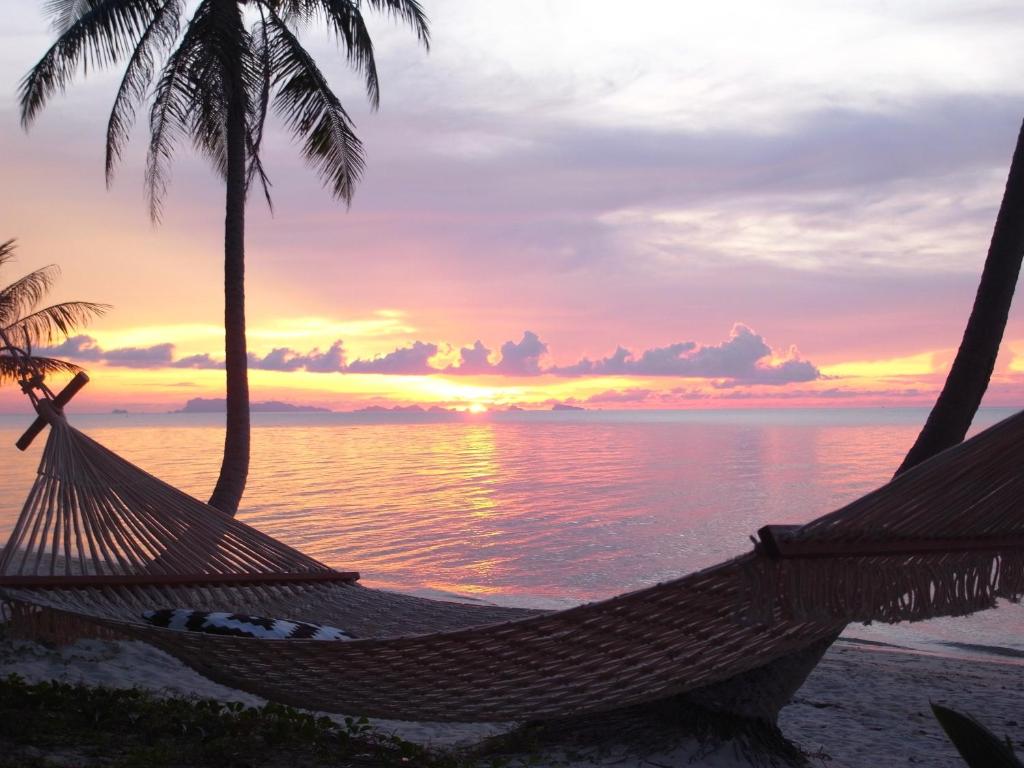 a hammock on the beach with a sunset at Jasmine & Tea House in Mae Nam