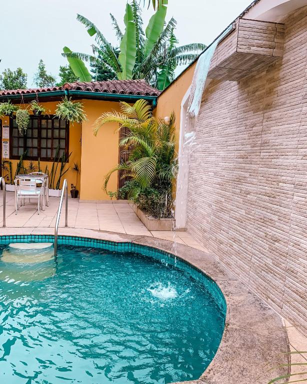 a swimming pool in front of a house at Pousada Vale Valparaíso Inn- Polo gastronômico in Petrópolis