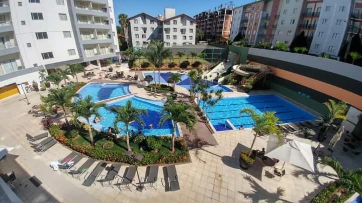 an overhead view of a pool with palm trees and buildings at Veredas Rio quente flat in Rio Quente