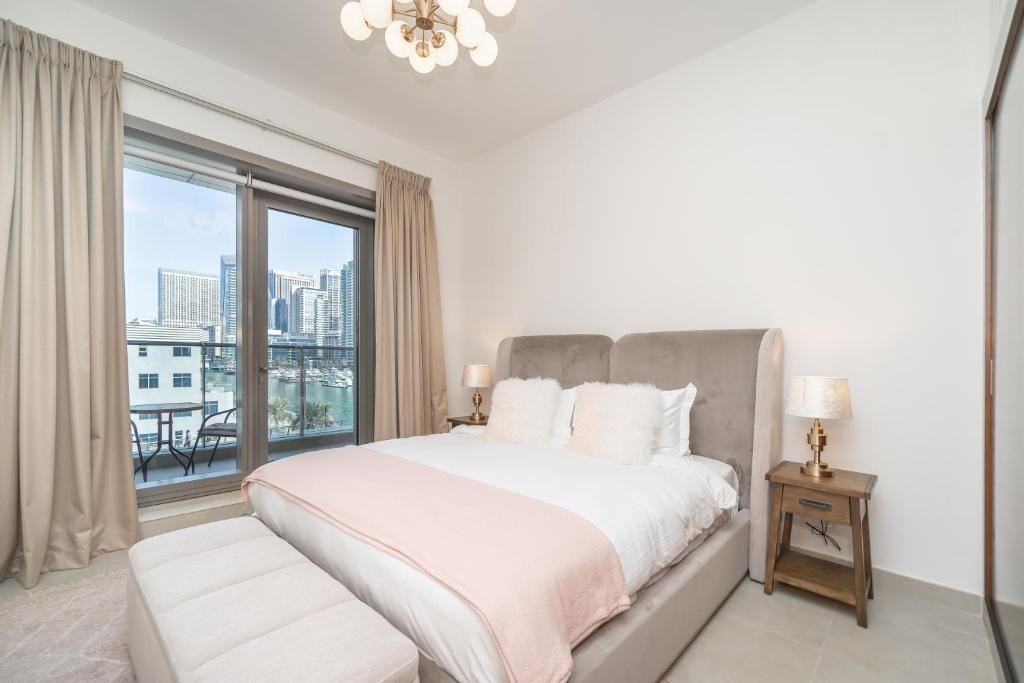 - une chambre avec un grand lit et une grande fenêtre dans l'établissement Luton Vacation Homes - Sparkle Towers, Dubai Marina 20AB 7, à Dubaï