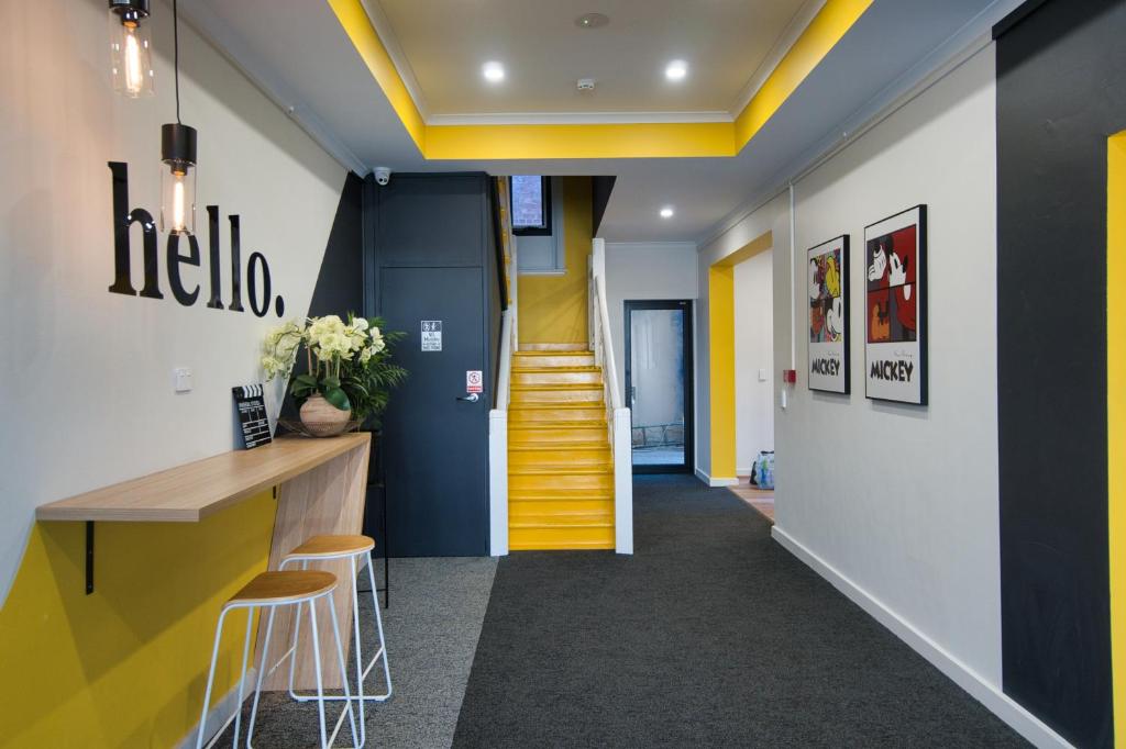 un corridoio con soffitti gialli e una scala gialla di Dreamy Stays Accommodation - Private Rooms with Shared Bathrooms a Adelaide