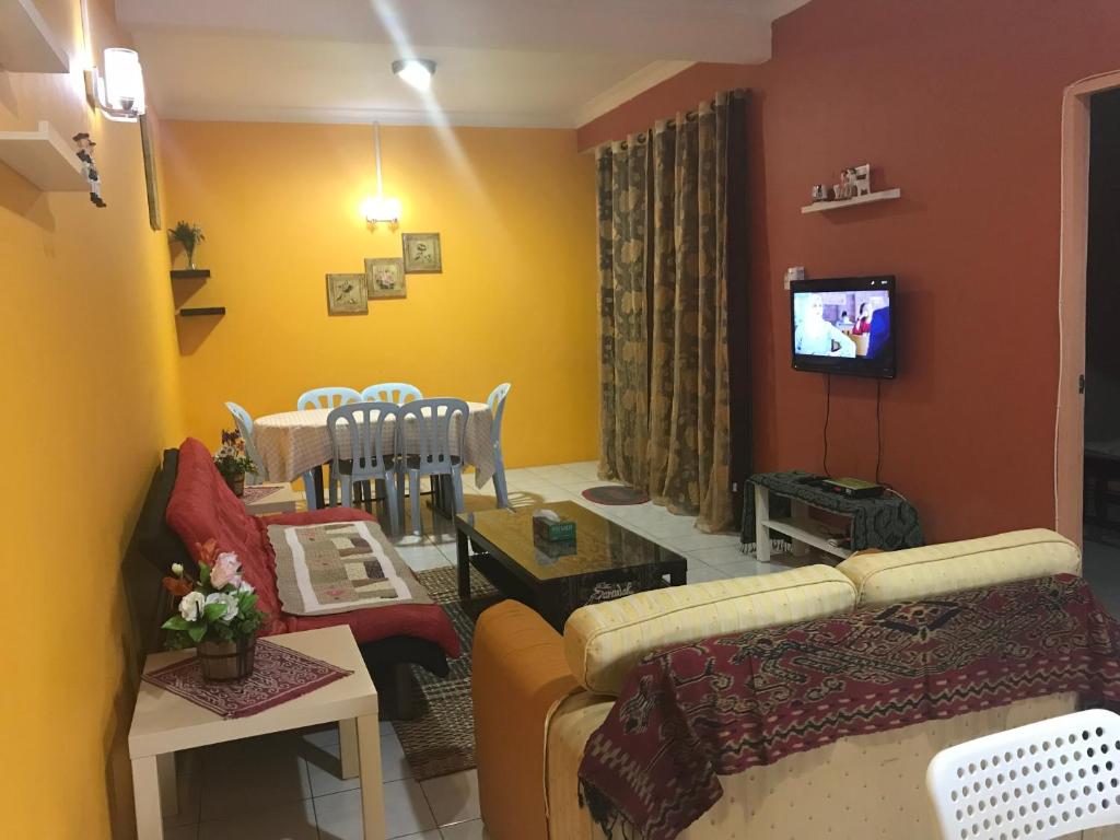 a living room with a couch and a dining room at Desa Ilmu Homestay in Kota Samarahan