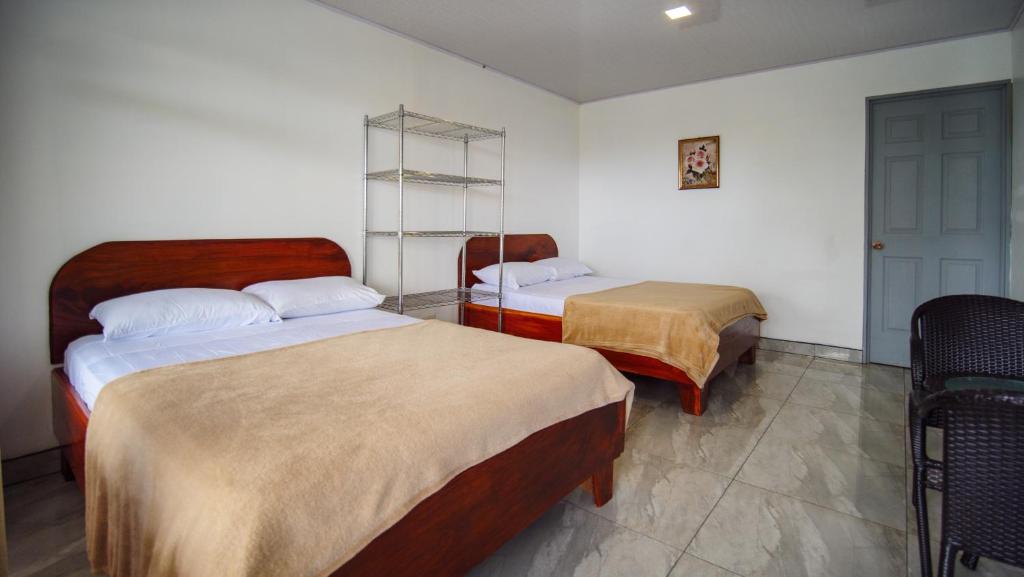 una camera d'albergo con due letti e una porta di Hostel Cattleya - Monteverde, Costa Rica a Monteverde Costa Rica