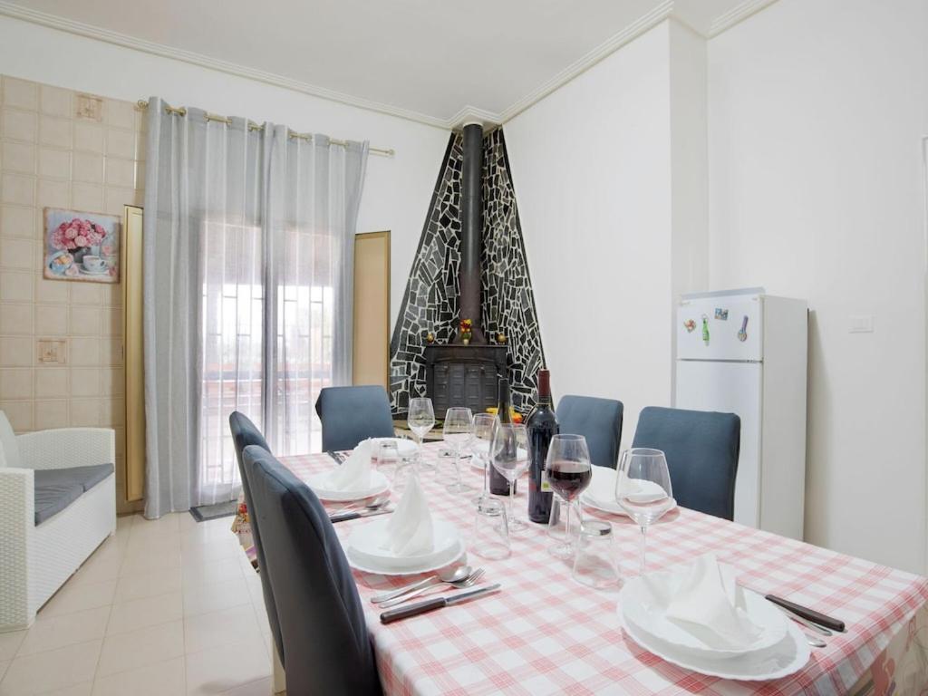 a dining room table with wine glasses and a fireplace at Belvilla by OYO VILLA AMATO in Comiso