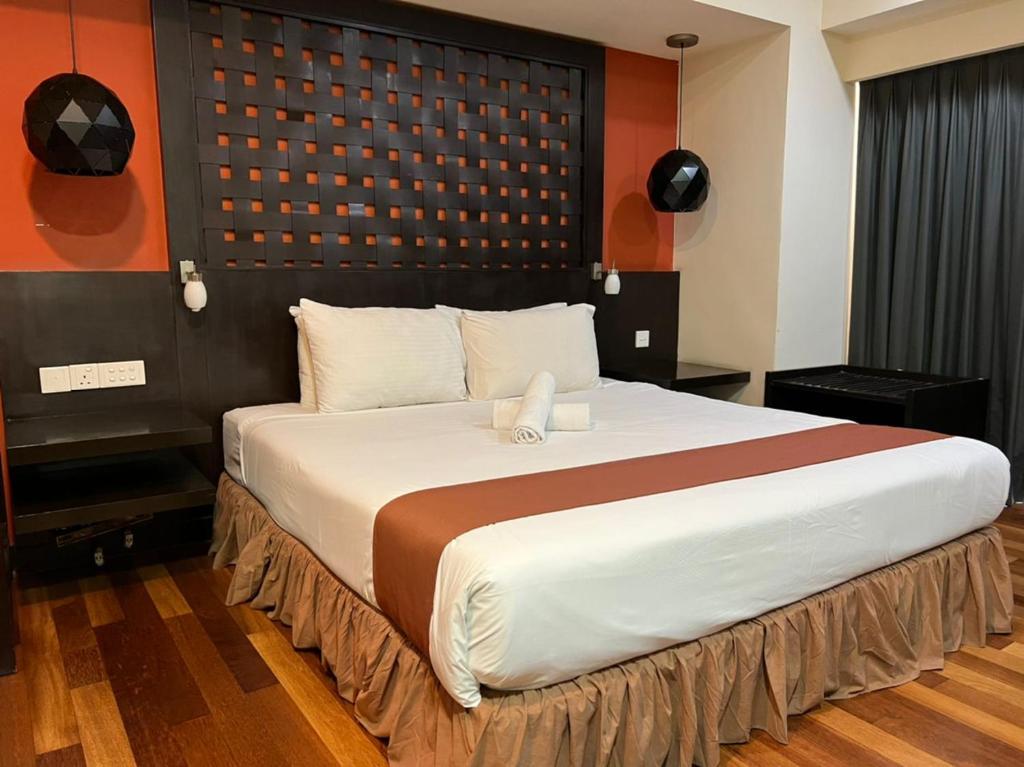 um quarto com uma cama grande num quarto em Raintree home Resort Suites At Bander Sunway Pyramid Hotel Tower em Petaling Jaya