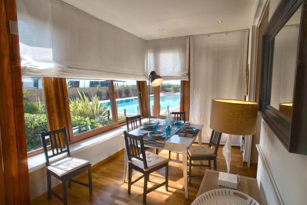 una sala da pranzo con tavolo, sedie e finestra di Beach House,Giardino,Piscina,Spiaggia, 6 posti a Viareggio