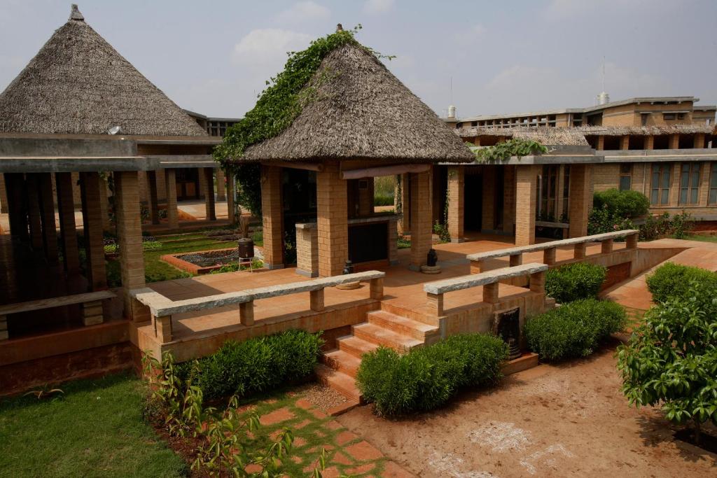 a patio area with a patio table and chairs at Our Native Village in Bangalore