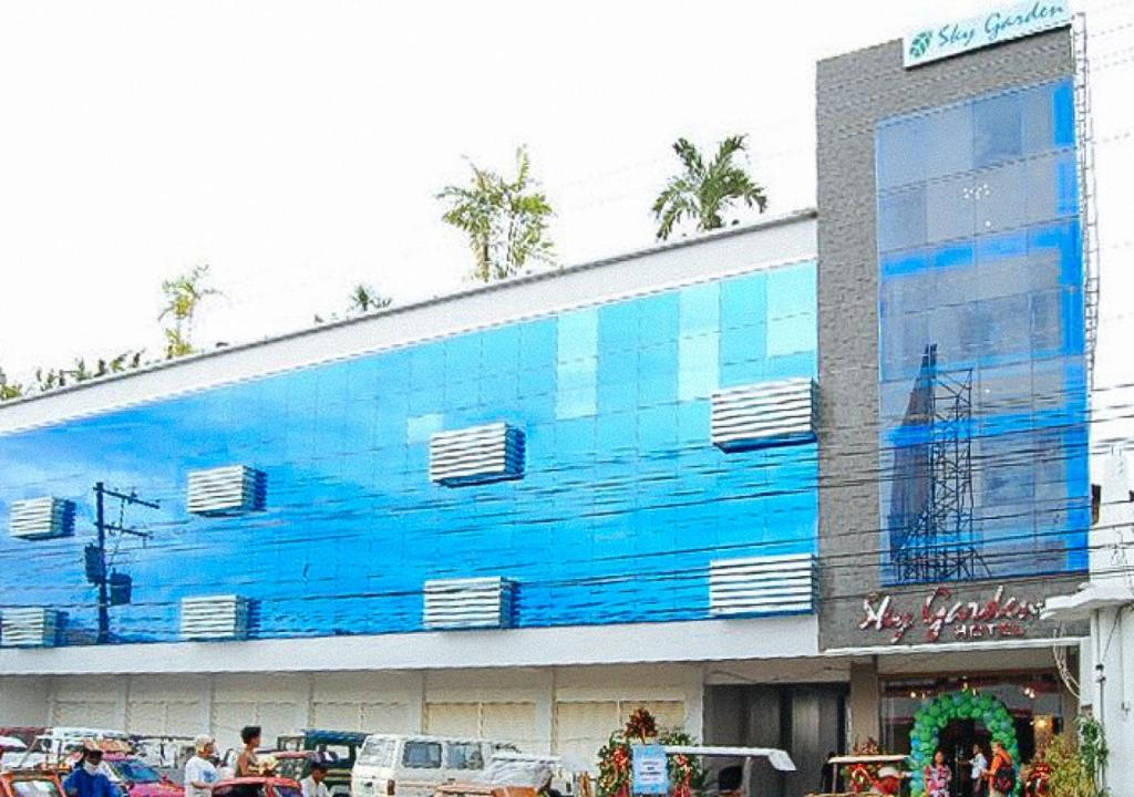 ロハスにあるSky Garden Hotel by RedDoorzの壁画のある青い大きな建物