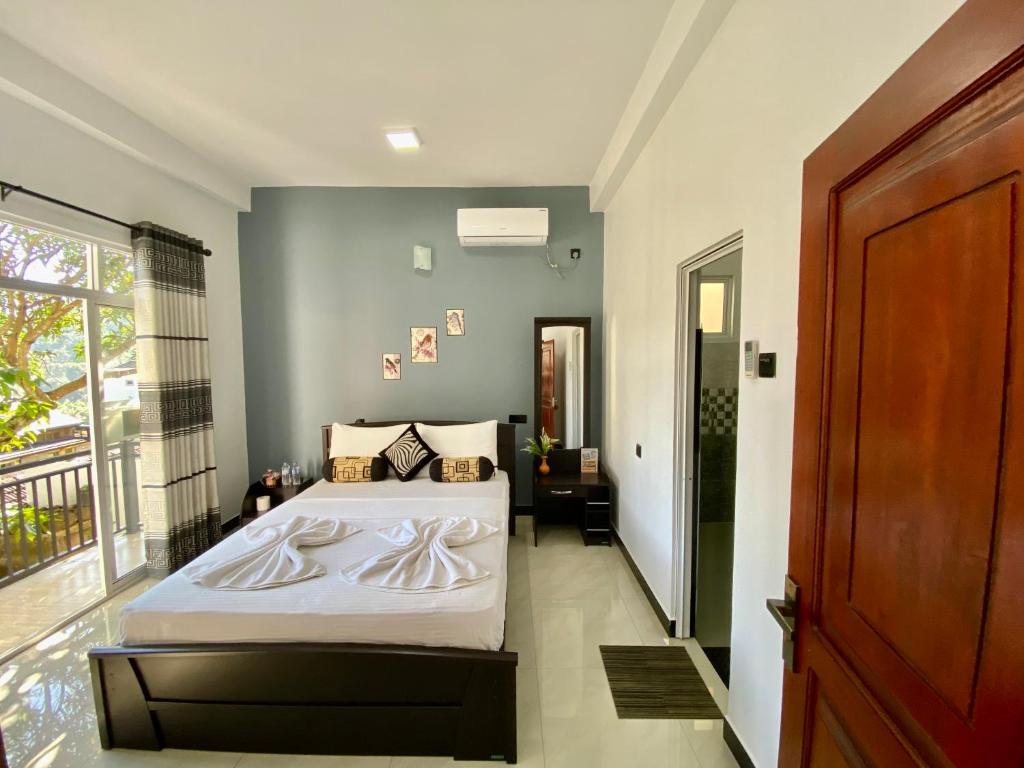 una camera da letto con un grande letto con lenzuola bianche di Mountain White Villa by Sunrise a Kandy