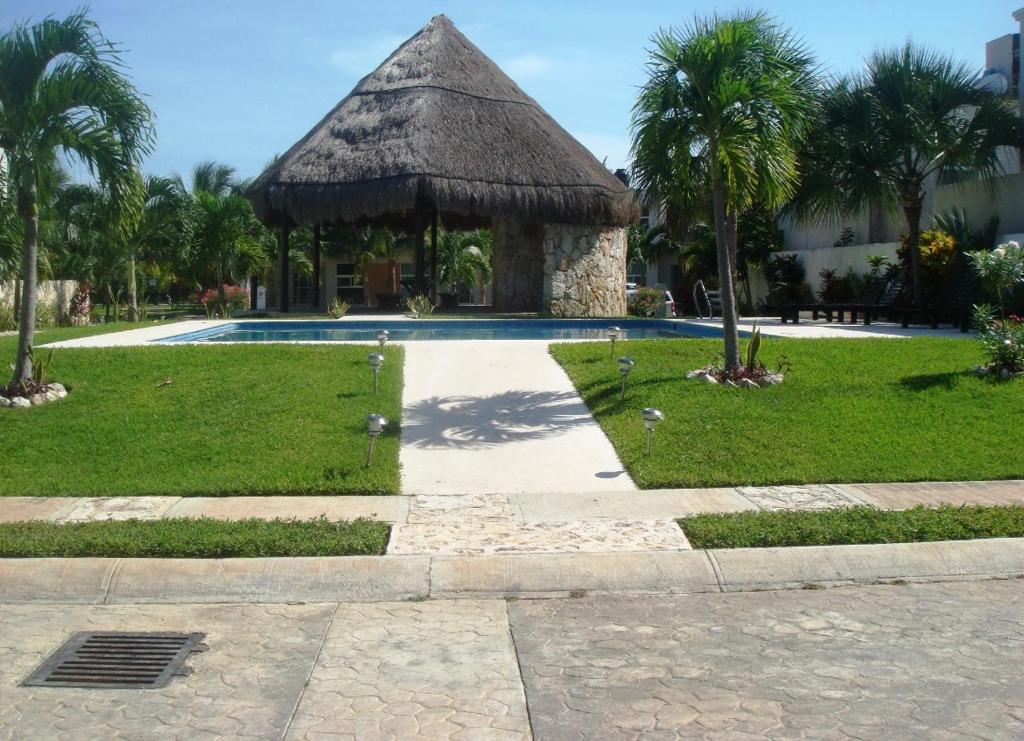 un complejo con piscina y cabaña en Acogedora casa en playa del Sol, en Playa del Carmen