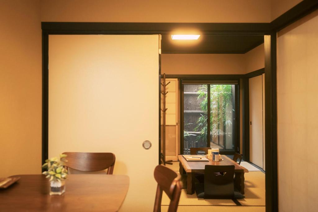 een eetkamer met een tafel en een tafel en een raam bij 谷町君 星屋 清水家 京都清水寺二年坂 in Kyoto