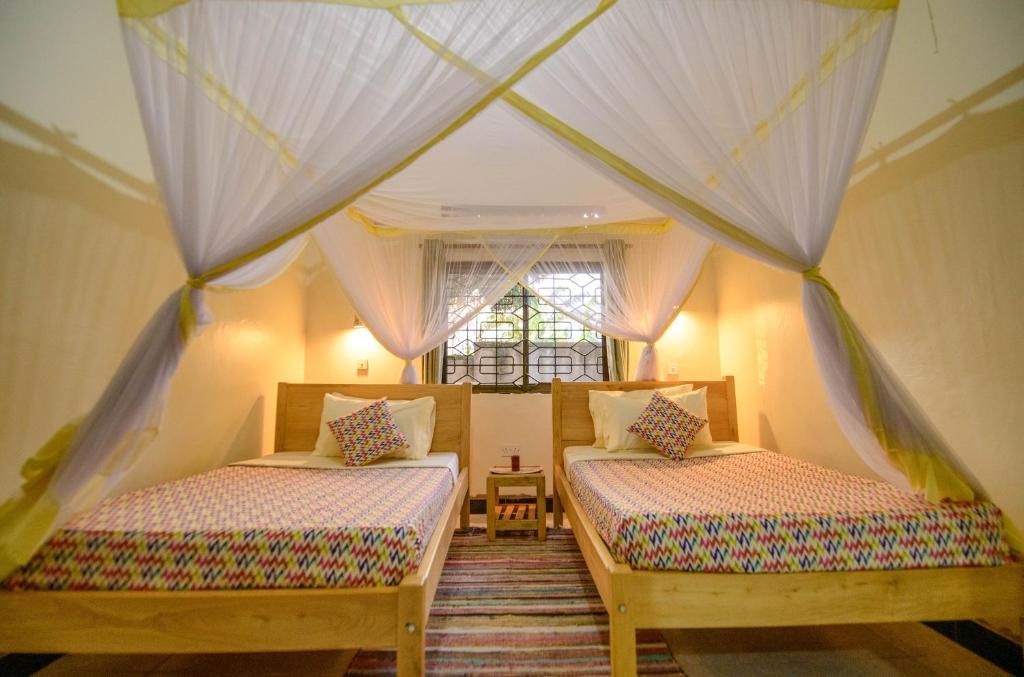 Postel nebo postele na pokoji v ubytování Cycad Entebbe Guest House