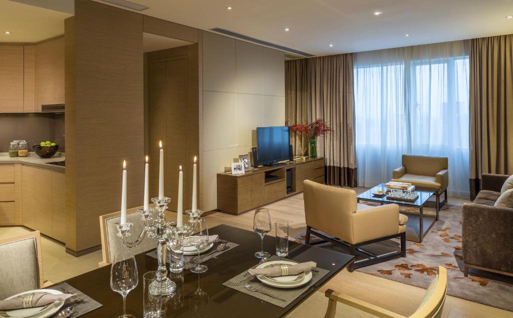 a living room with a dining table and a kitchen at Fraser Suites Guangzhou in Guangzhou