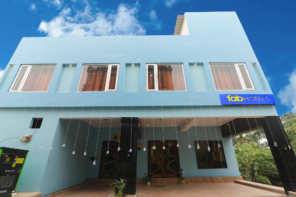 un bâtiment bleu avec un panneau sur lequel figure un panneau dans l'établissement FabHotel Blueark, à Lucknow