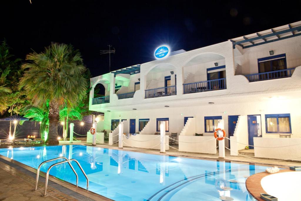 a hotel with a swimming pool at night at Ariadni Blue in Neos Marmaras