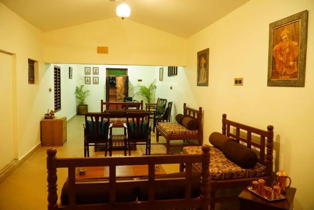 a room with a table and chairs and a dining room at TANJORE INN in Thanjāvūr