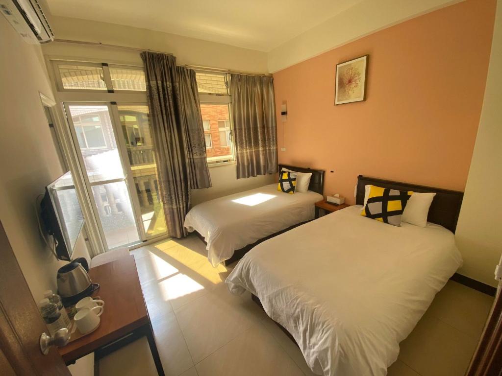 金寧鄉的住宿－拼圖民宿，酒店客房设有两张床和电视。