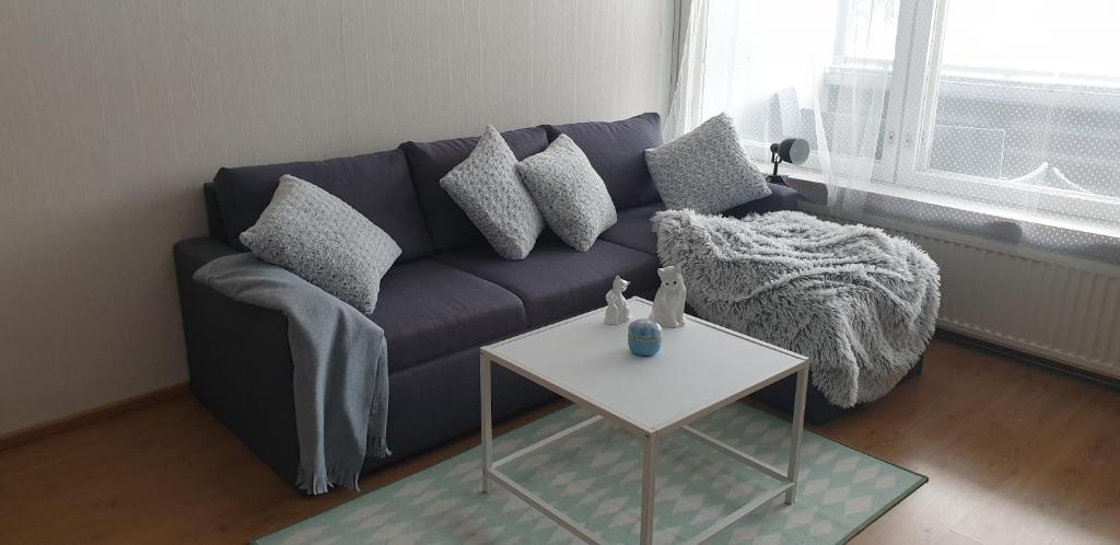 sala de estar con sofá azul y mesa en City apartment Pieksämaki, en Pieksämäki