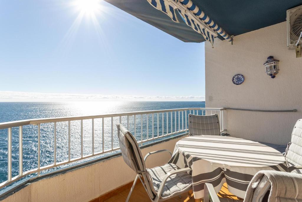 uma varanda com uma mesa e cadeiras e o oceano em Apartment with sea view em Almuñécar