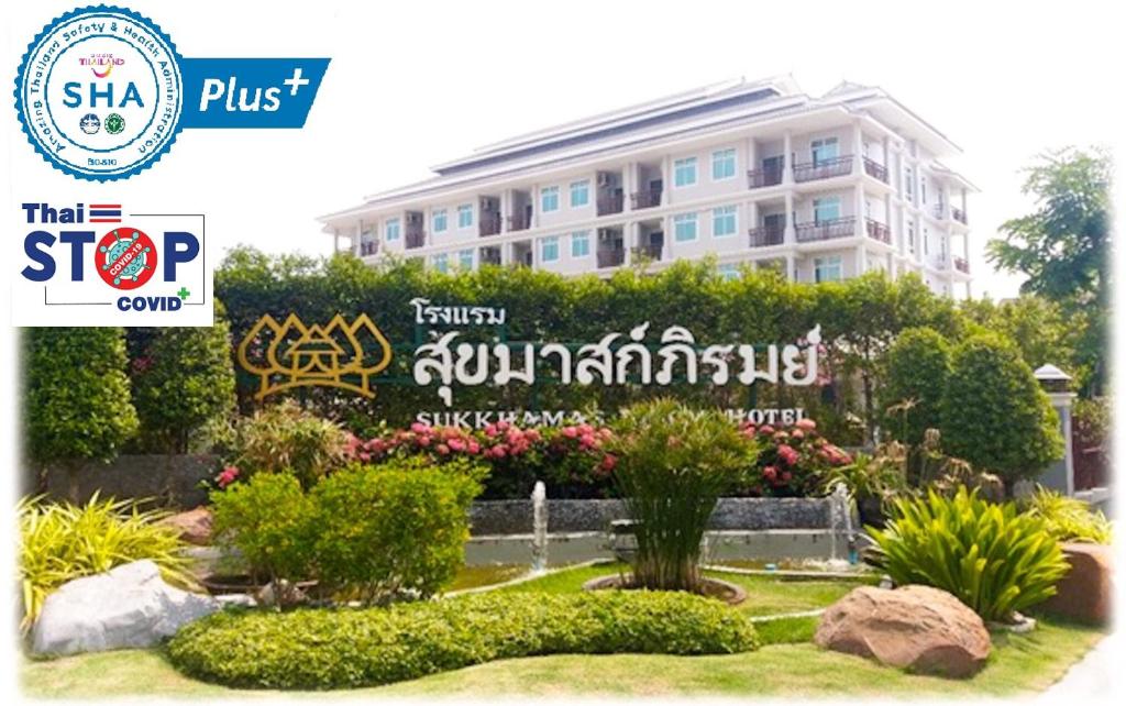 un bâtiment avec un panneau en face d'un jardin dans l'établissement Sukkhamas Pirom, à Nakhon Ratchasima