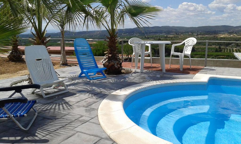 a group of chairs and a table next to a pool at Casa Gabriel in Picassent