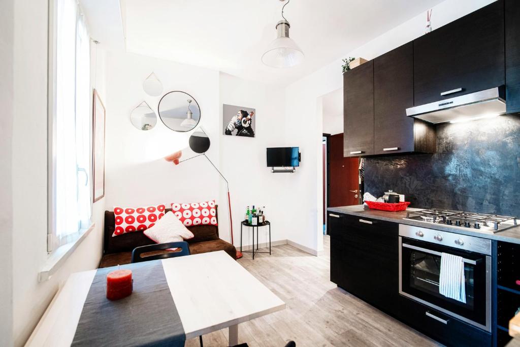 una cucina con armadi neri e un tavolo in una stanza di Apartment a Step from Lake Como a Como