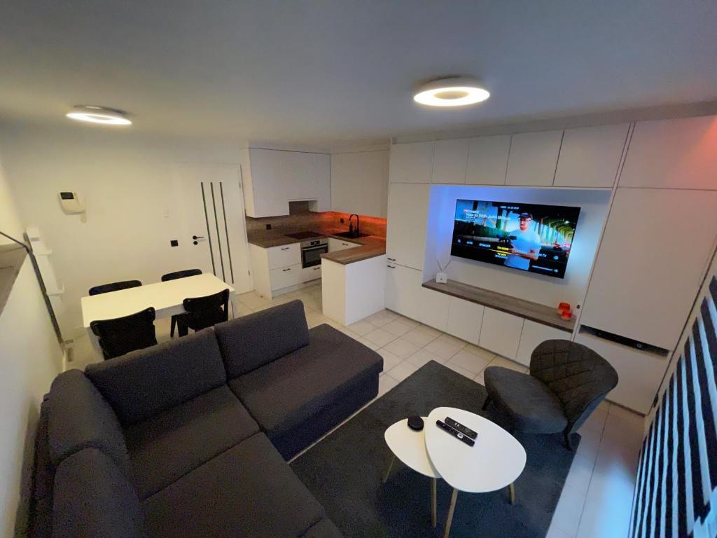ein Wohnzimmer mit einem Sofa, einem Tisch und einem TV in der Unterkunft Luxe appartement I 2 slaapkamers I 2 x dubbel bed I 75m van het strand I Nieuwpoort-Bad in Nieuwpoort