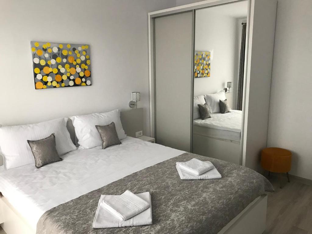 1 dormitorio con 1 cama blanca grande y espejo en NEW Aparthotel Floresti en Floreşti