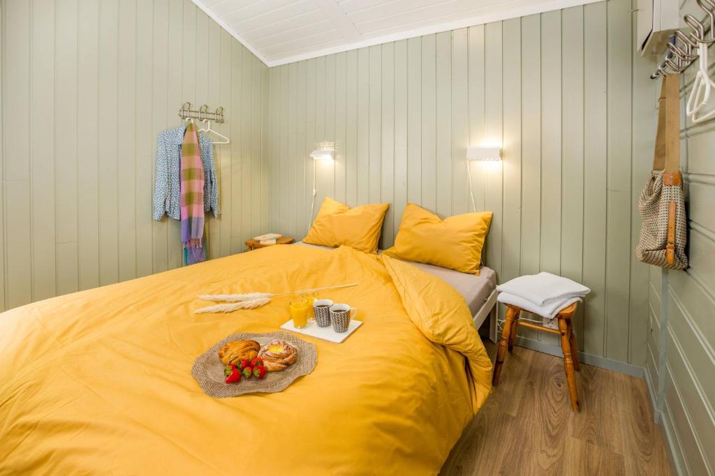 a yellow bed with a tray of food on it at Flåm Camping & Cabins in Flåm