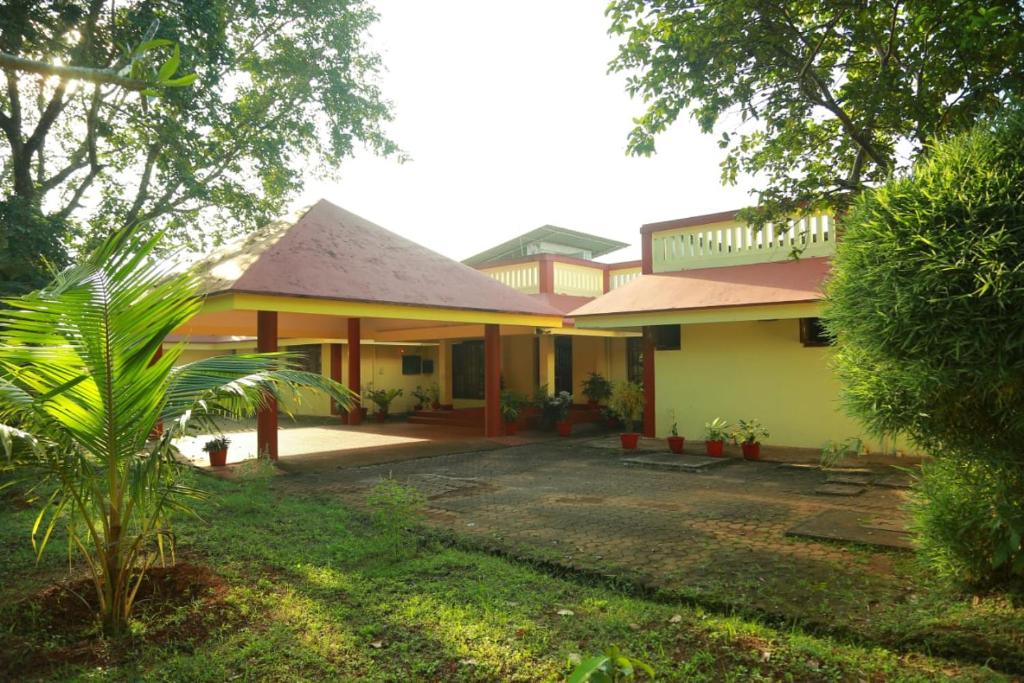 una casa con un patio frente a ella en KTDC Tamarind en Kondotti