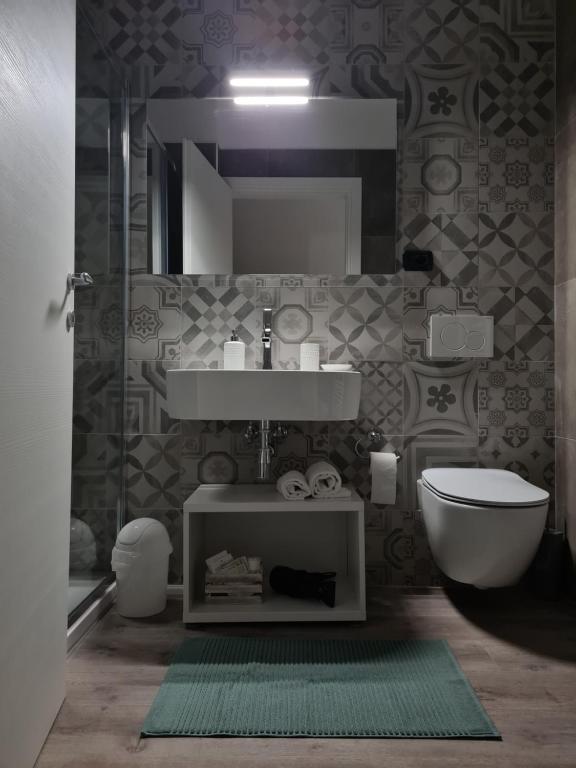 a bathroom with a sink and a toilet and a mirror at PincoPancoRooms in Acquasanta Terme