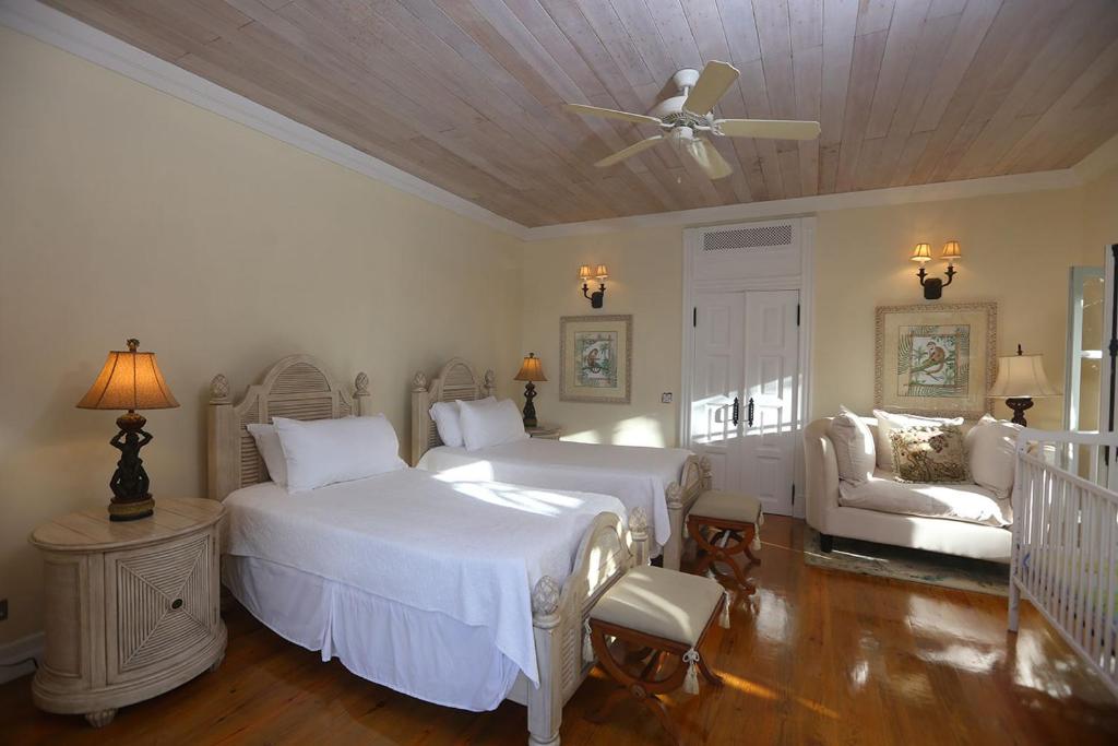 a bedroom with two beds and a ceiling fan at Arc en Ciel in Soufrière